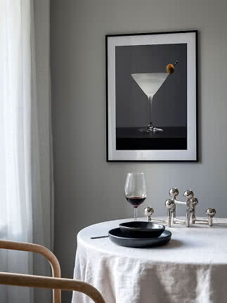 Gerahmtes Poster mit Cocktailglas und Olive über einem gedeckten Tisch