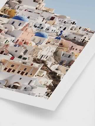 Angled photo of whitewashed houses with blue domes in a Greek hillside village