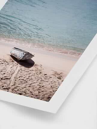 Small weathered boat on a sandy beach by calm turquoise water