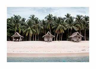 Three small beach huts among palm trees on a white sandy shore by calm turquoise water.