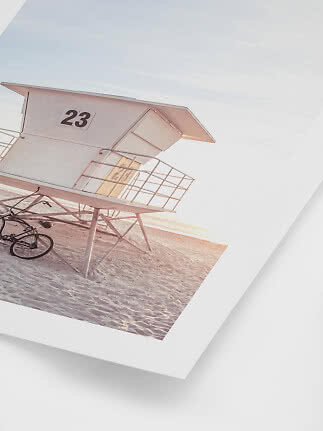 Fotodruck eines Rettungsturms 23 am Strand bei Sonnenuntergang mit Fahrrad im Sand