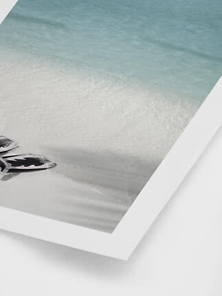 Ingelijste strandfoto met turquoise water, wit zand en zwemvliezen in de hoek