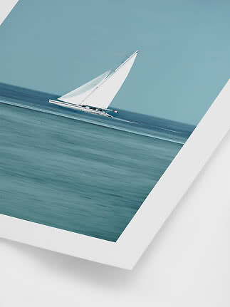 White sailboat on a calm blue sea under a clear sky
