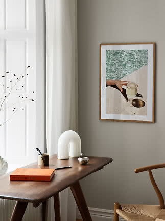 Framed photo on wall above a wooden table in a bright, modern room
