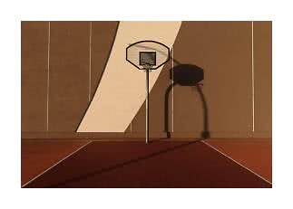 Canestro da basket su campo esterno davanti a un muro marrone con lunga ombra al sole