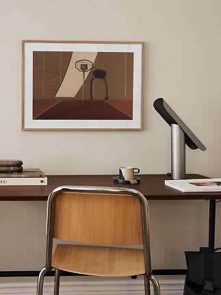 Scrivania con sedia in legno, lampada da tavolo moderna e stampa basket incorniciata