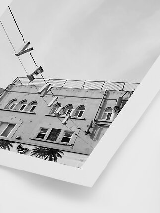 Black-and-white print of a building with arched windows and hanging street lights