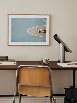 Bureau avec chaise, lampe et affiche encadrée au mur