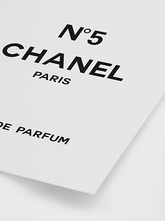 Närbild av vit Chanel No. 5 parfymask med svart logotyp