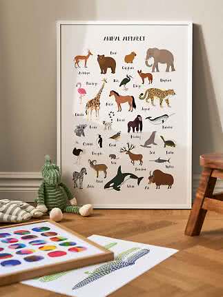 Framed Animal Alphabet poster with colorful animal illustrations, leaning against the wall in a kids' room