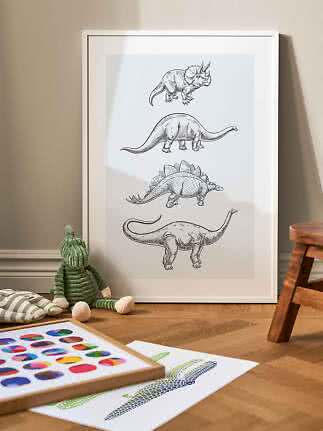 Framed dinosaur poster with four black-and-white sketches, leaning against a nursery wall