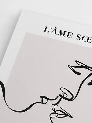 Nærbillede af minimalistisk kunsttryk med sort stregtegning og teksten "L’ÂME SOE"