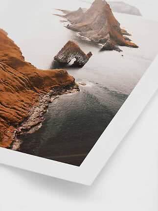 Poster showing an aerial view of a dramatic rocky coastline and sea