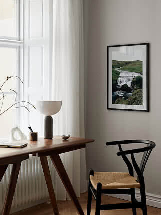 Indrammet foto af vandfald over skrivebord i lyst, minimalistisk rum