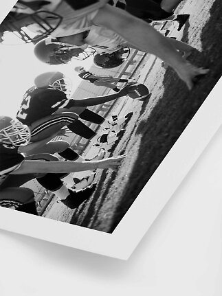 Schwarz-Weiß-Foto von American-Football-Spielern in Aufstellung auf dem Feld.