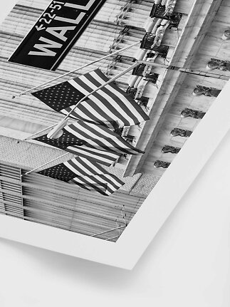 Sort-hvidt foto af amerikanske flag på en bygning med Wall Street-skilt