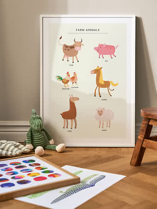 Framed farm animals nursery poster leaning on the floor in a child's room