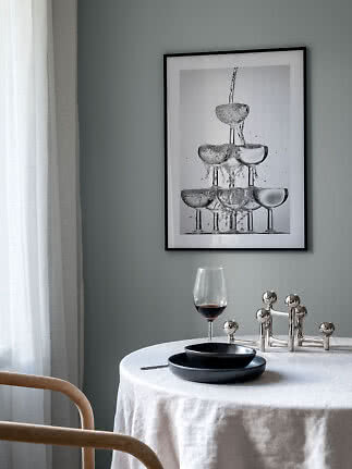 Indrammet sort-hvid plakat med stablede glas og vandsprøjt over et dækket bord