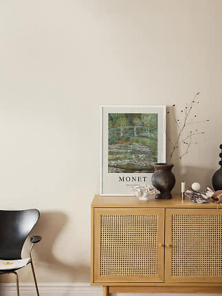 Monet poster in white frame on oak cabinet with cane doors and decorative vases