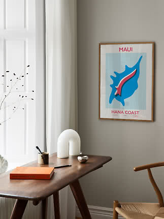 Gerahmtes Maui Hana Coast Poster an grauer Wand über einem Holzschreibtisch