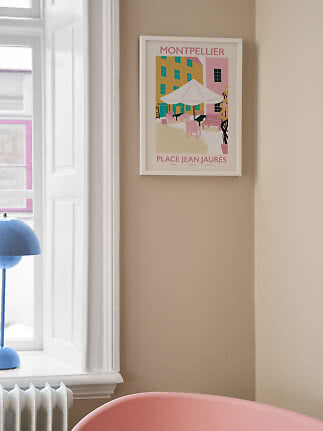 Gerahmtes Montpellier-Poster an beiger Wand neben Fenster mit pastellfarbener Caféplatz-Illustration