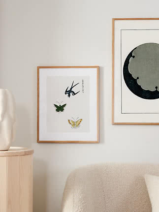 Gerahmter Kunstdruck mit Schwalbe und zwei Schmetterlingen an heller Wand