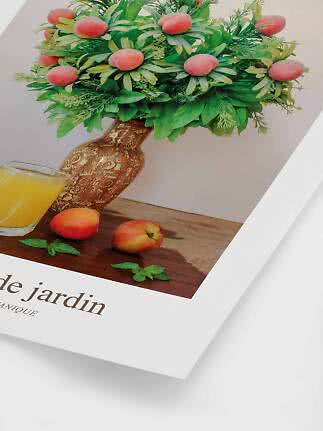 Bouquet de feuilles vertes et fleurs couleur pêche dans un vase brun sur une table