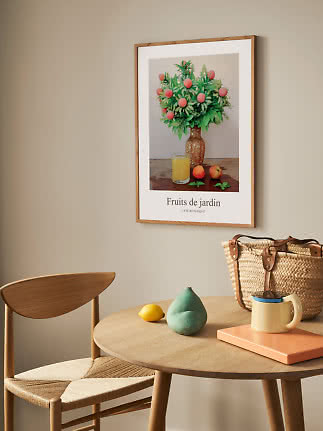 Affiche encadrée d’un bouquet de pêches en vase au-dessus d’une table en bois dans un coin repas clair