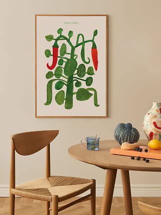 Póster enmarcado de una planta de chile verde con dos chiles rojos sobre una mesa