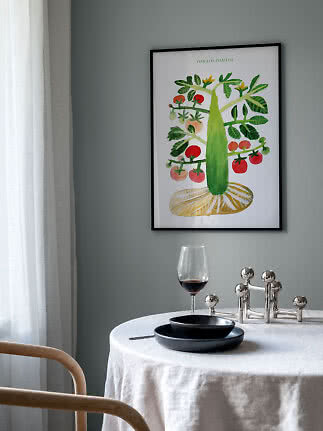 Gerahmter Kunstdruck mit Tomatenpflanze und roten Tomaten an grauer Wand über gedecktem Tisch