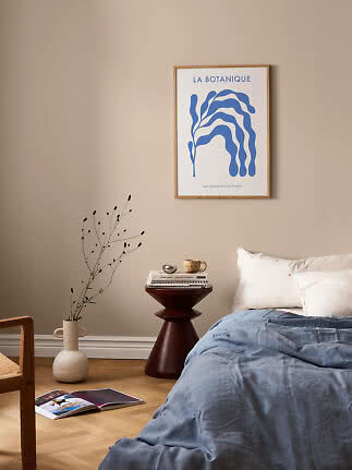 Poster botanico con foglia astratta blu in cornice di legno sopra il letto
