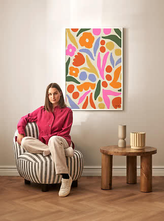 Lámina floral abstracta colorida enmarcada sobre una silla en un salón moderno