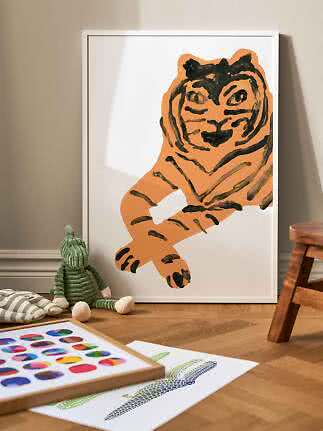 Weiß gerahmtes Poster mit orangefarbener Tigerillustration, an die Wand im Kinderzimmer gelehnt