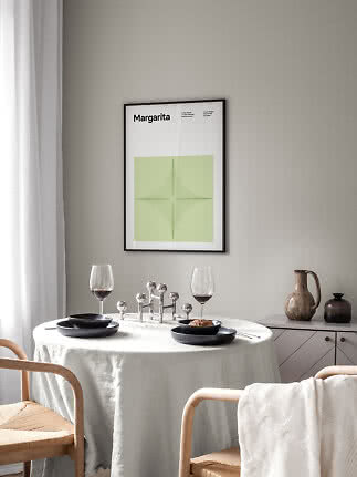 Gerahmtes Margarita-Poster mit grüner Grafik über einem gedeckten Esstisch