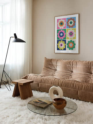 Cozy living room with beige sofa, black floor lamp, and colorful floral wall art