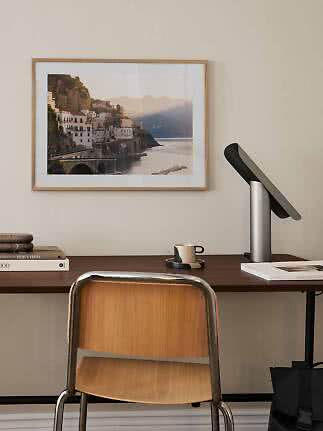Desk with chair, lamp and framed coastal photo on the wall