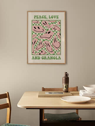 Indrammet plakat med teksten "Peace, Love and Granola" og lyserøde smilemotiver på grøn ternet baggrund