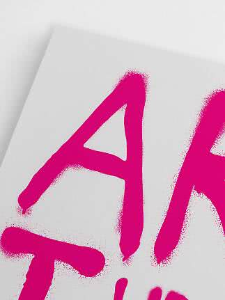 Närbild av vit poster med stora neonrosa spraymålade bokstäver