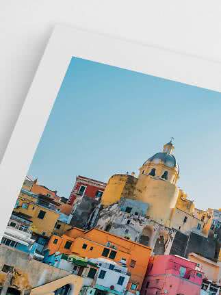 Framed photo of colorful buildings and a church dome under a clear blue sky