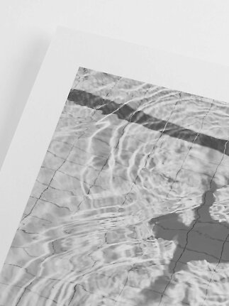 Sort-hvid fotokunst af bølgende vand over fliser med hvid passepartout