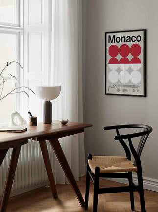 Affiche Monaco encadrée avec cercles rouges et blancs au mur au-dessus d’un bureau et d’une chaise noire