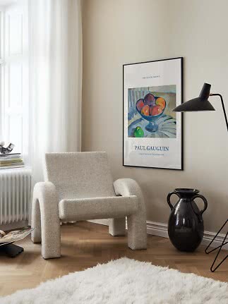 Affiche encadrée de Paul Gauguin au-dessus d’un fauteuil beige dans un coin lumineux moderne