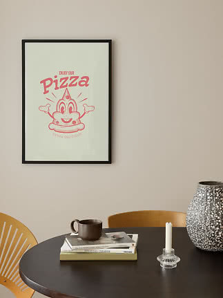 Indrammet pizza-plakat med lyserød retroillustration på beige væg over spisebord
