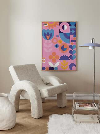 Färgglad poster med blommor och geometriska former i träram på vägg i modernt vardagsrum