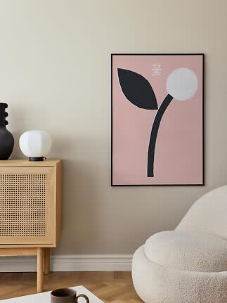 Affiche florale abstraite encadrée rose et noire sur un mur de salon moderne
