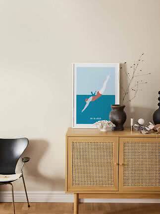 Affiche encadrée de plongeon sur buffet en bois clair avec portes cannage et vases déco
