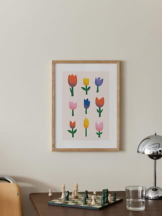 Poster incorniciato con nove tulipani colorati sopra un tavolo con scacchiera e lampada