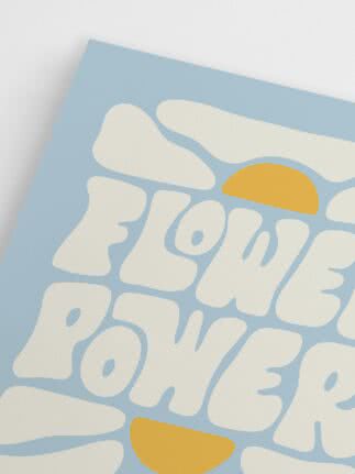 Blue poster with large white letters and yellow suns reading “Flower Power”.