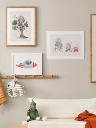 Children's room with framed animal and fantasy prints above a bench with soft toys