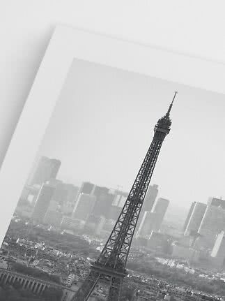 Schwarz-weißer Print des Eiffelturms vor der Pariser Skyline, schräg aufgenommen.